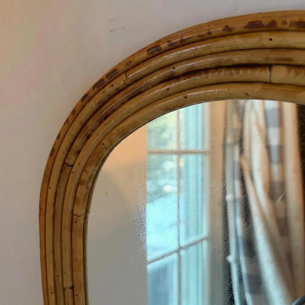 Vintage Arched rattan mirror with a natural, aged finish.